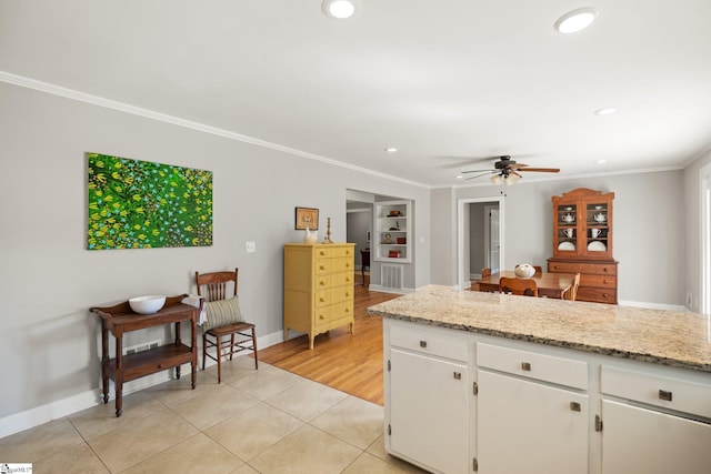 kitchen featuring white cabinets, built in shelves, light tile patterned floors, and crown molding