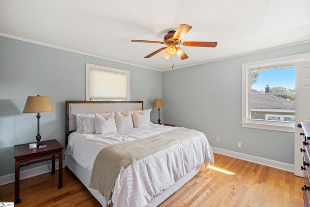 bedroom featuring ceiling fan, light wood-type flooring, and crown molding