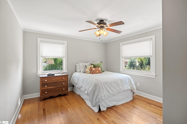 bedroom with ceiling fan, crown molding, and light hardwood / wood-style flooring