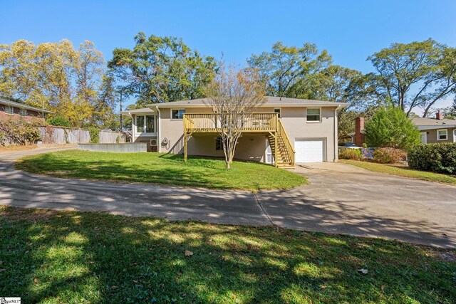 view of front facade with a garage, a deck, and a front lawn