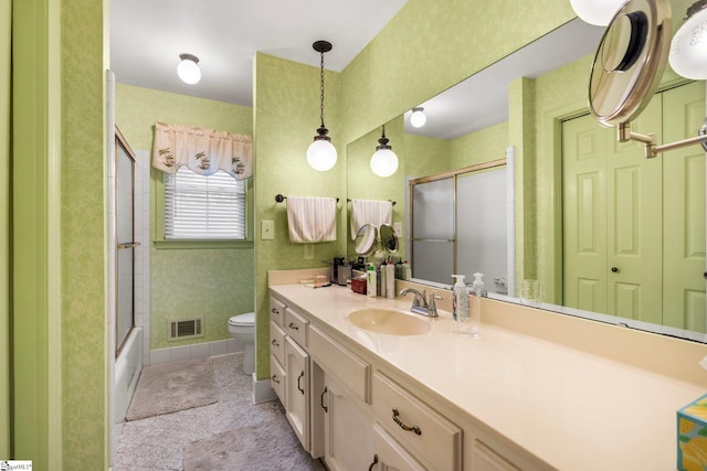 full bathroom featuring vanity, toilet, and bath / shower combo with glass door