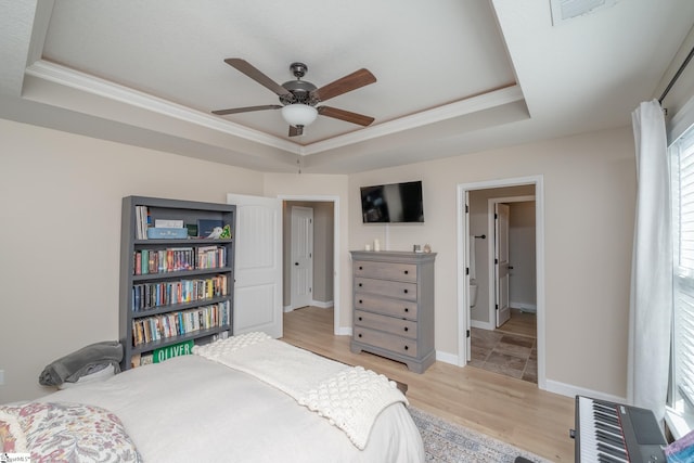 bedroom featuring a raised ceiling, light hardwood / wood-style flooring, multiple windows, and ceiling fan