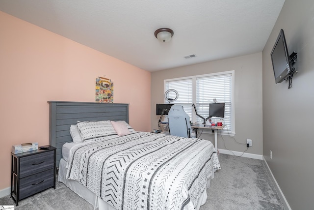 bedroom with light carpet and a textured ceiling