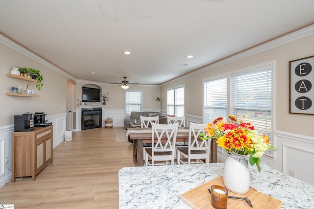 dining space featuring ceiling fan, a healthy amount of sunlight, light hardwood / wood-style floors, and crown molding