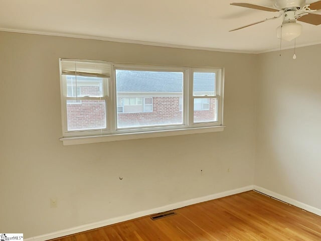 empty room with wood-type flooring, ceiling fan, and crown molding