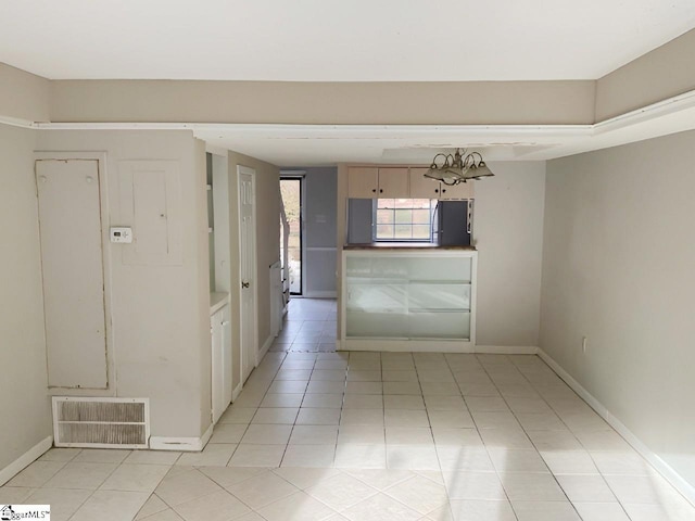 corridor with a notable chandelier and light tile patterned flooring