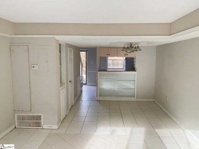2530 E N St Unit 11C, Greenville, SC 29615 - empty room featuring light tile patterned flooring, baseboards, and a chandelier