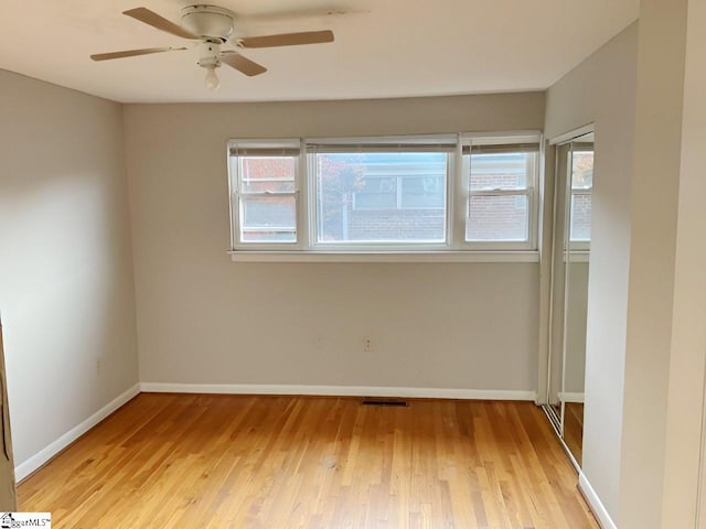 empty room with light hardwood / wood-style flooring and ceiling fan