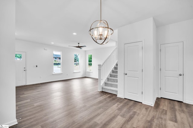 unfurnished living room featuring dark hardwood / wood-style floors and ceiling fan with notable chandelier