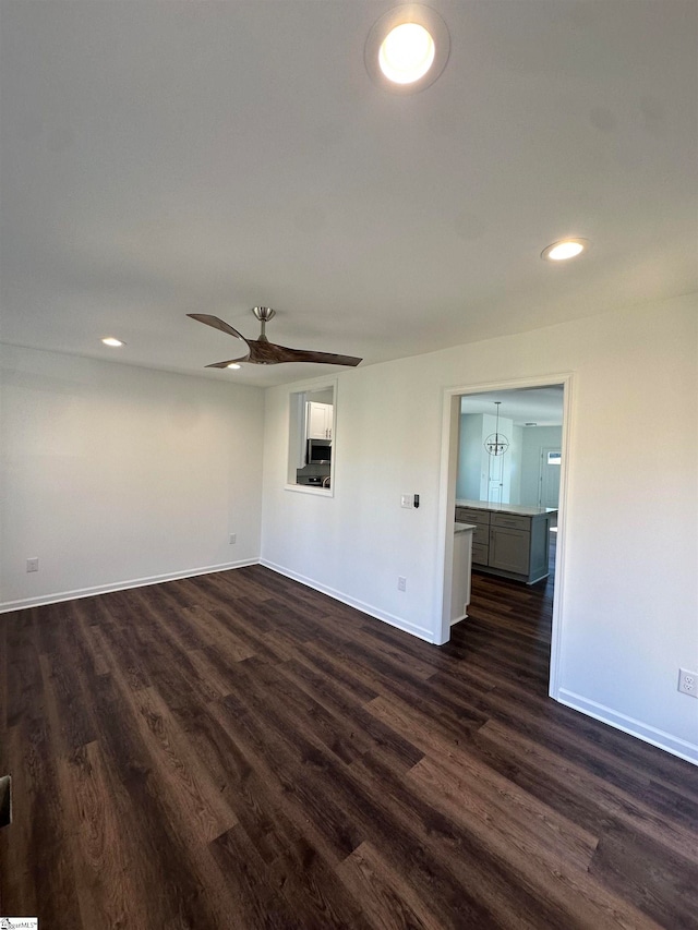 empty room with ceiling fan and dark hardwood / wood-style flooring