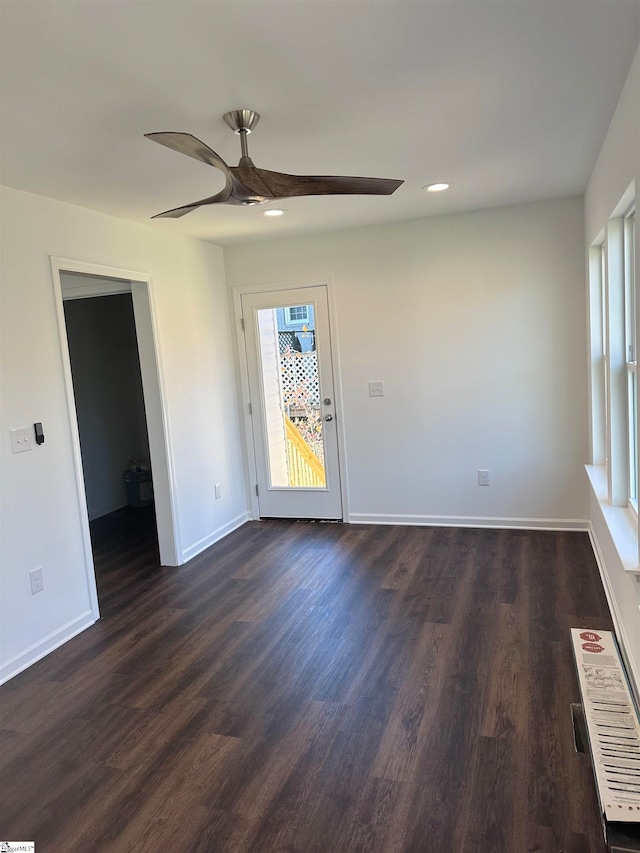 empty room with ceiling fan and dark hardwood / wood-style flooring