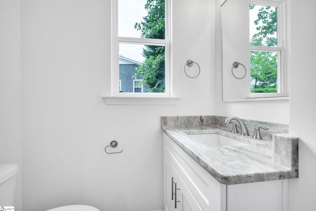 bathroom featuring vanity, toilet, and plenty of natural light