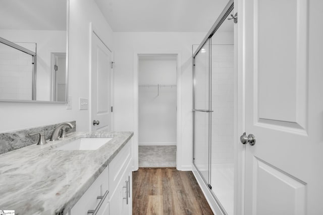 bathroom with vanity, wood-type flooring, and walk in shower