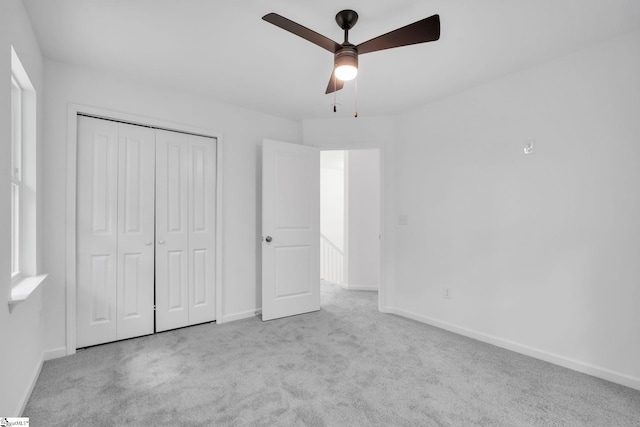 unfurnished bedroom with ceiling fan, a closet, and light carpet