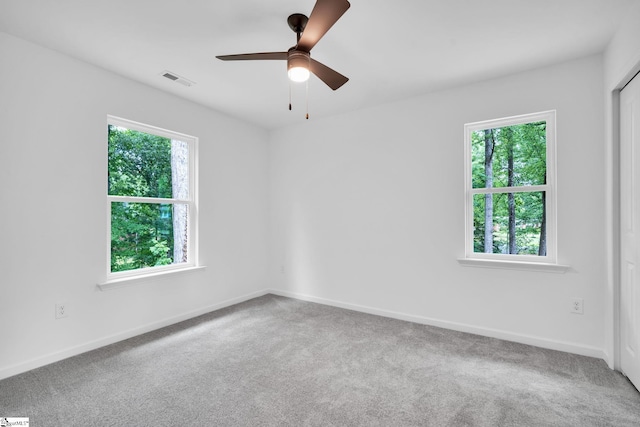 carpeted empty room with ceiling fan and a healthy amount of sunlight