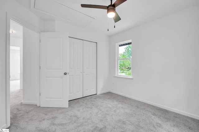 unfurnished bedroom featuring light carpet, a closet, and ceiling fan