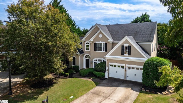 view of front of house featuring a garage and a front lawn