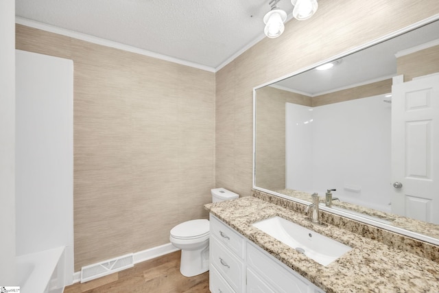 bathroom featuring a textured ceiling, vanity, toilet, and crown molding