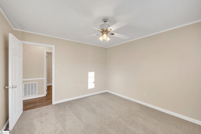 spare room featuring light carpet, ceiling fan, and ornamental molding