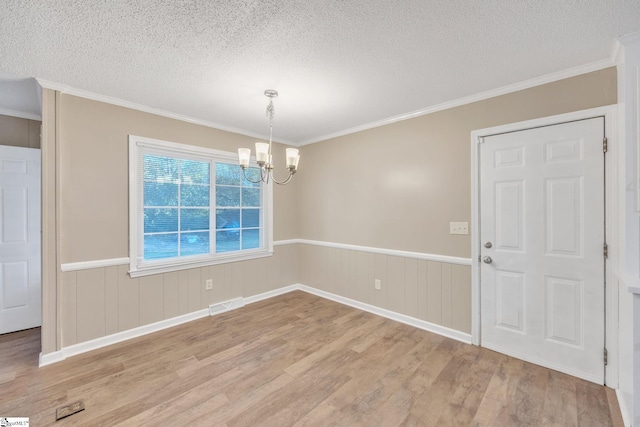 unfurnished dining area featuring a textured ceiling, a notable chandelier, and light wood-type flooring