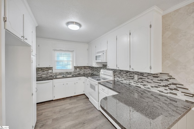 kitchen with white cabinetry, sink, tasteful backsplash, light hardwood / wood-style flooring, and white appliances