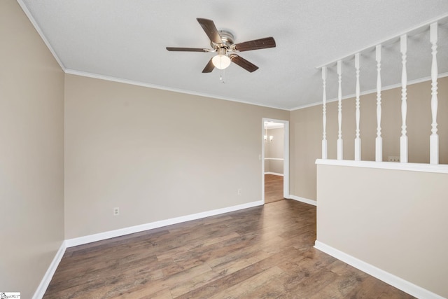 empty room with ceiling fan, hardwood / wood-style floors, a textured ceiling, and ornamental molding