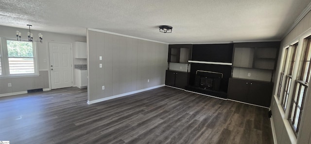 unfurnished living room featuring a textured ceiling, dark hardwood / wood-style flooring, and crown molding