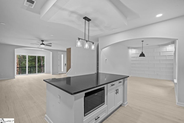 kitchen featuring black microwave, ceiling fan, decorative light fixtures, light hardwood / wood-style flooring, and white cabinetry