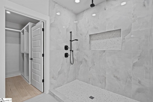 bathroom featuring a tile shower and hardwood / wood-style flooring