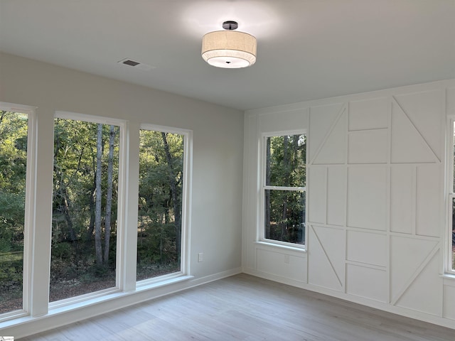 empty room with light hardwood / wood-style floors and a wealth of natural light