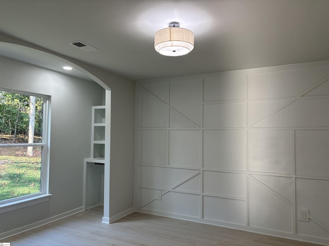 spare room featuring a wealth of natural light and light hardwood / wood-style floors