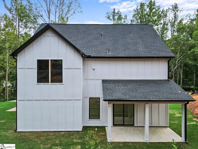 rear view of house with a patio and a lawn