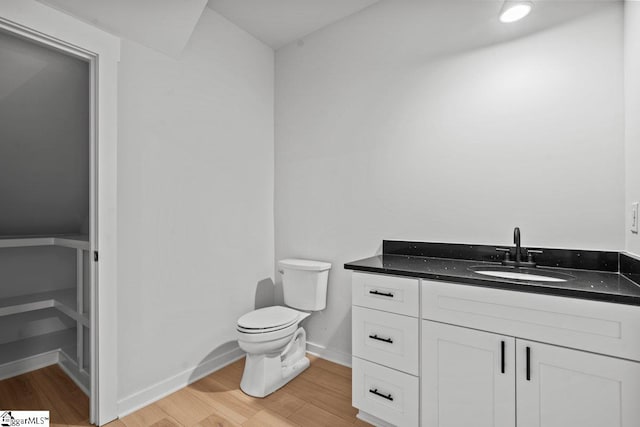 bathroom with toilet, vanity, and hardwood / wood-style flooring