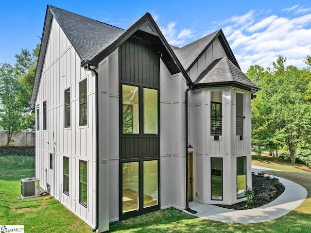 view of outdoor structure featuring a yard and central AC