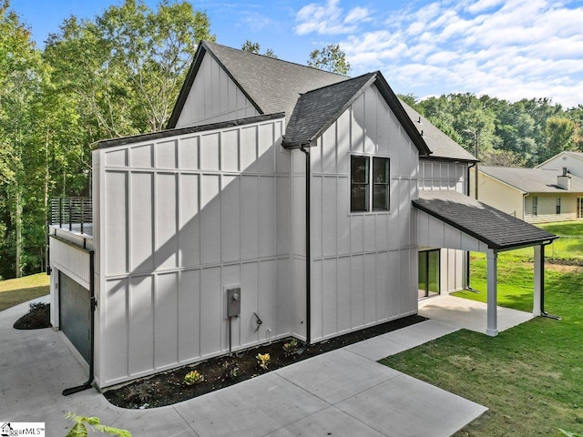 view of side of home featuring a yard and a garage