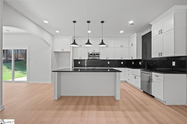 kitchen featuring decorative light fixtures, light hardwood / wood-style floors, white cabinetry, and stainless steel appliances