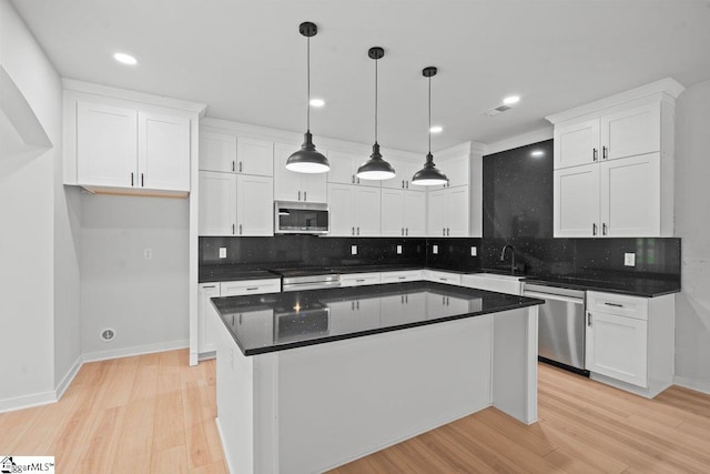 kitchen featuring white cabinets, decorative backsplash, a kitchen island, and stainless steel appliances