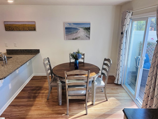 dining space with wood-type flooring and sink