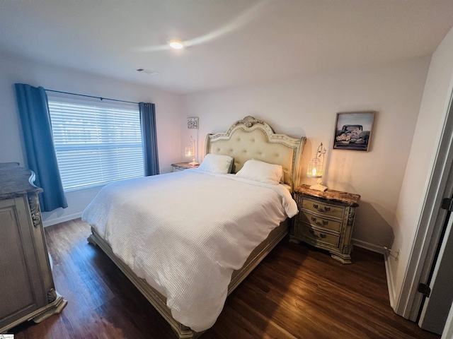 bedroom with dark hardwood / wood-style floors