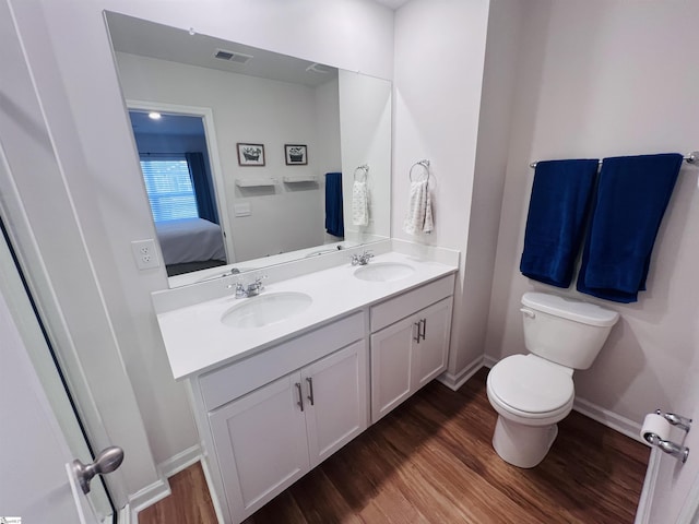 bathroom with hardwood / wood-style floors, vanity, and toilet