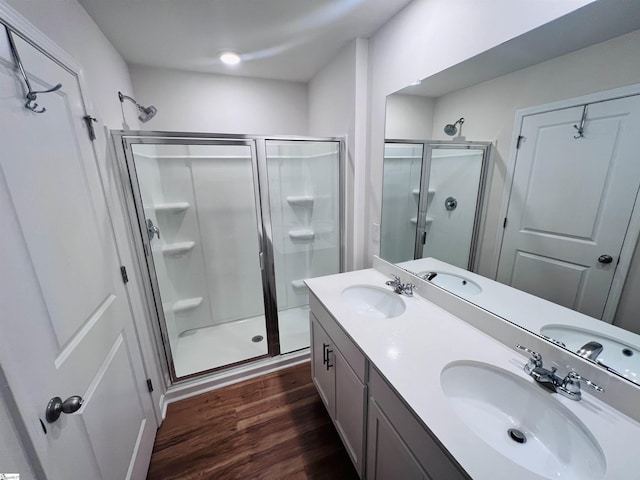 bathroom with wood-type flooring, vanity, and a shower with door