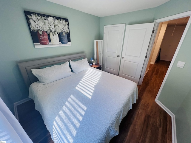 bedroom with dark hardwood / wood-style flooring and a closet