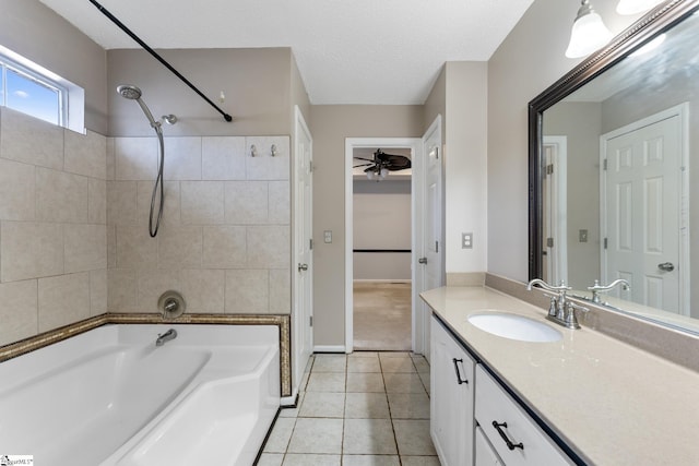 bathroom featuring ceiling fan, tile patterned floors, a textured ceiling, vanity, and tiled shower / bath