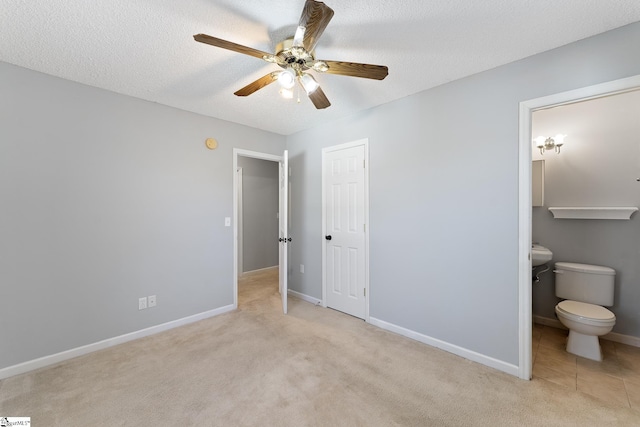 bedroom with light carpet, a textured ceiling, ensuite bathroom, and ceiling fan