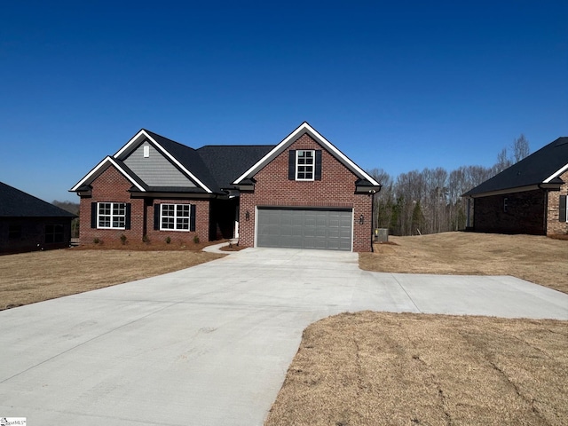 view of front facade featuring a garage, brick siding, driveway, and a front lawn