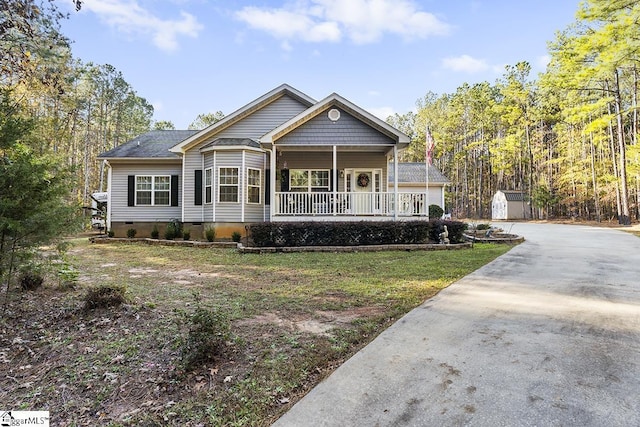 view of front of property with a porch and a storage shed