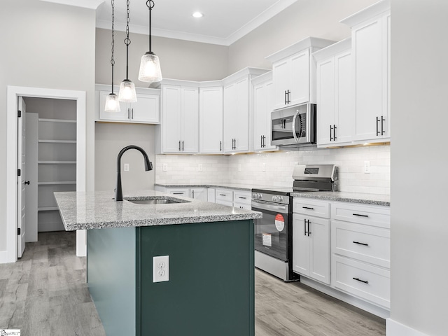 kitchen featuring white cabinets, sink, an island with sink, and appliances with stainless steel finishes