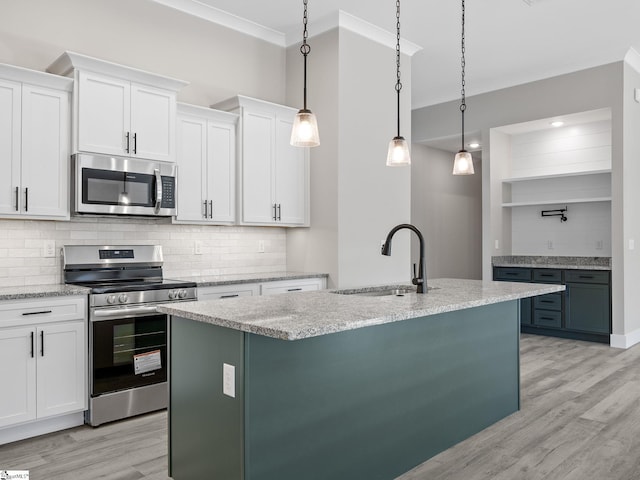 kitchen featuring pendant lighting, sink, light wood-type flooring, appliances with stainless steel finishes, and white cabinetry