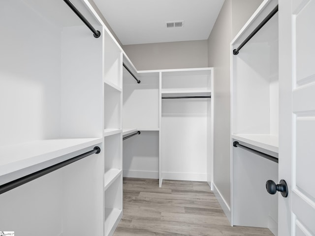 spacious closet with light hardwood / wood-style flooring