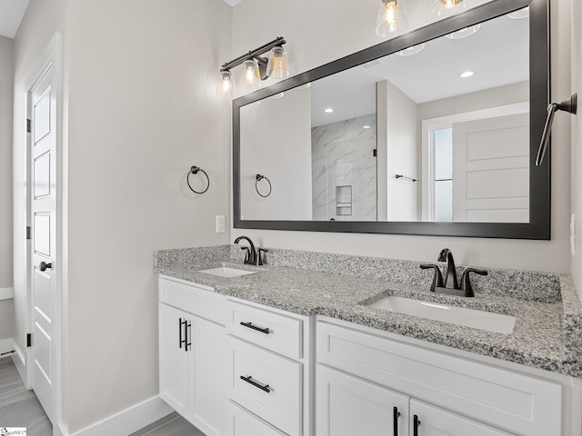 bathroom featuring a tile shower and vanity